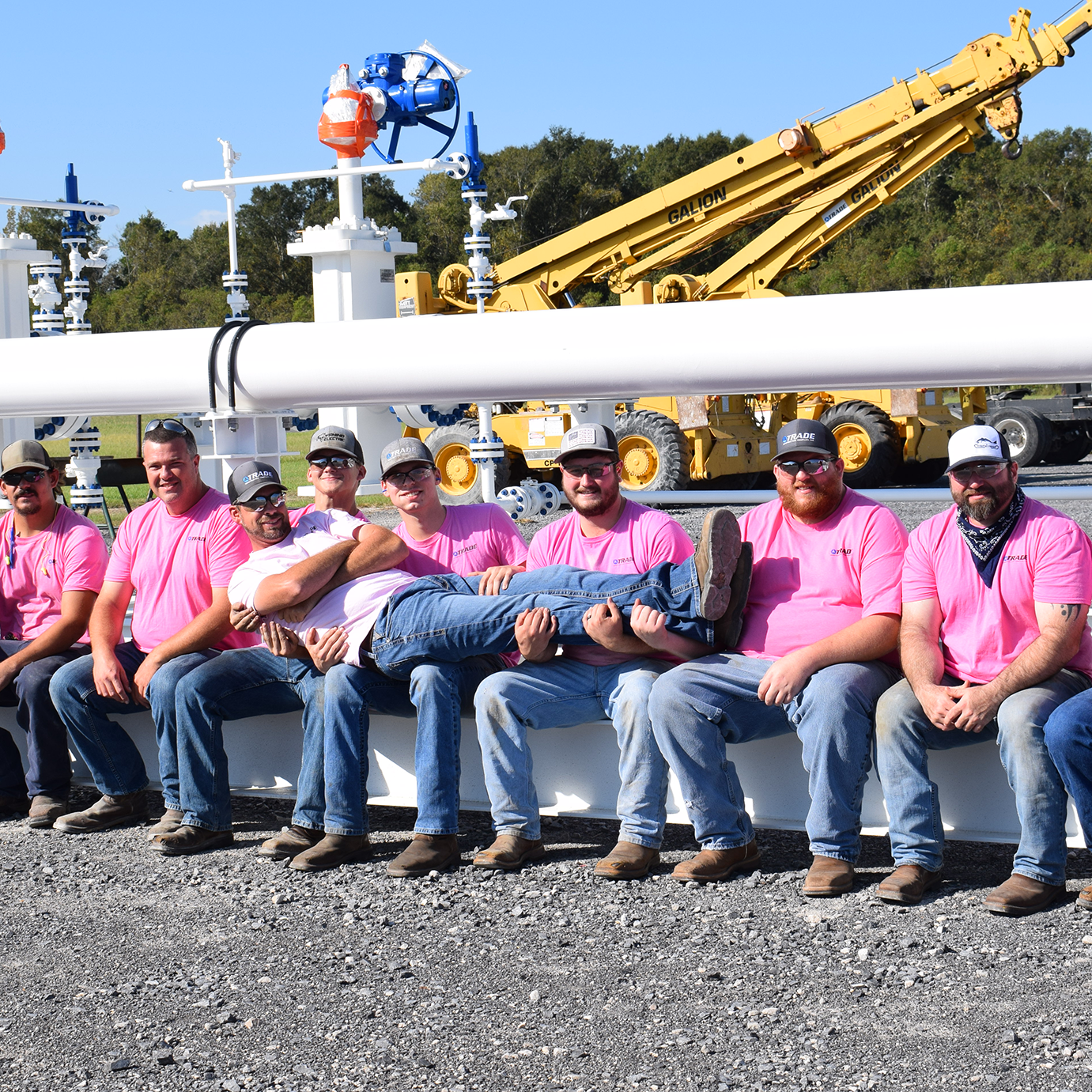 A group of Trade employees in front of equipment