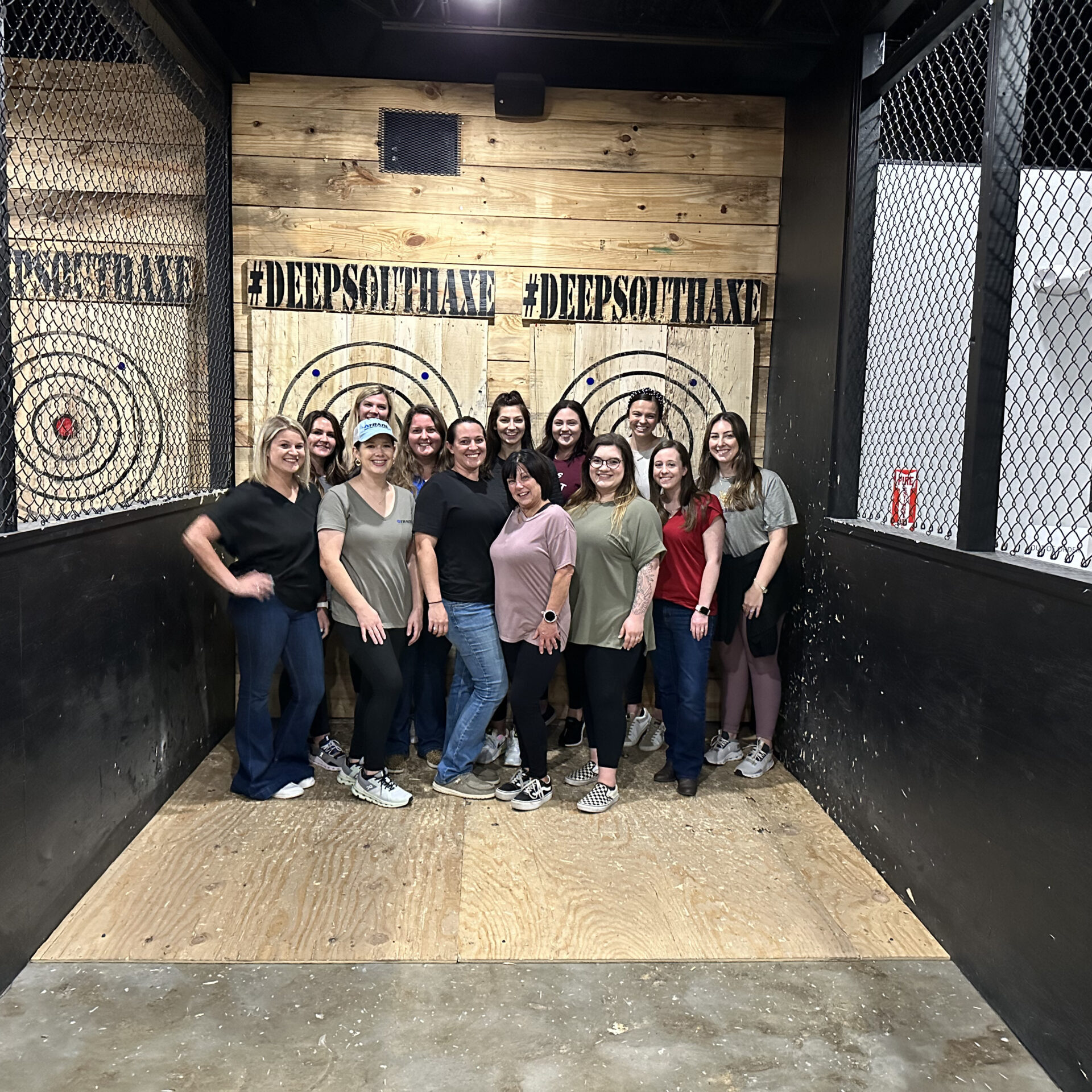 A group of Trade employees at a team outing event doing axe throwing